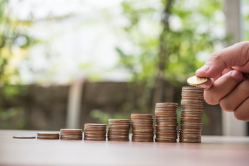 Saving money concept . hand putting money coin stack