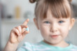 Little girl holding a pill addict. Focus on hands