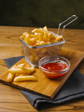 Close-up Of French Fries With Ketchup Served On Wooden Table