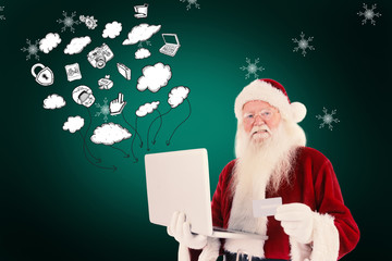 Wall Mural - Santa pays with credit card on a laptop against green background with vignette