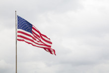 American Flag With A Blue Cloudy Sky