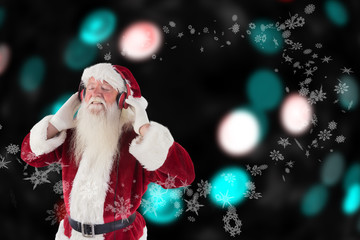 Wall Mural - Santa Claus enjoys some music against digitally generated twinkling light design 