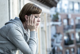 Fototapeta  - young attractive unhappy depressed lonely woman looking sad on the balcony at home