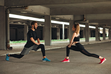 Wall Mural - Young couple stretching before workout outdoor