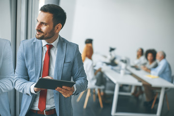 Wall Mural - Young businessman with digital tablet in office