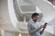 © ReeldealHD images - African American using smartphone in modern office