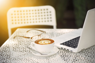 Wall Mural - On the garden table there are notebooks, coffee, glasses and cakes.