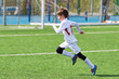 © Sergey Ryzhov - Running boy soccer player training on football field