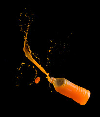 Wall Mural - Orange juice up from a plastic bottle on a black background,orange juice splash