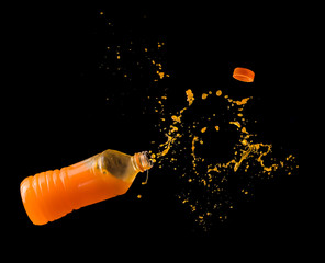 Wall Mural - Orange juice up from a plastic bottle on a black background,orange juice splash