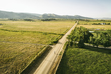 High Angle View Of Road Amidst Field By Mountains