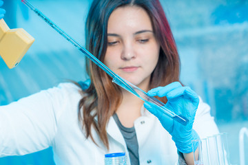 Wall Mural - Young attractive female scientist  load liquid sample substance probe in the scientific chemical research laboratory