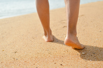 Wall Mural - Closeup of man's feet at the shore