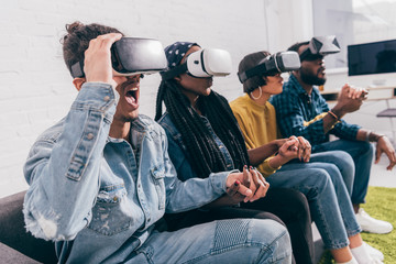 Wall Mural - group of young multicultural friends using virtual reality headsets