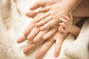 Wall Mural - newborn child hand. closeup of baby hand into parents hands. family, maternity and birth concept.