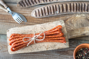 Sticker - Smoked sausages on the wooden background