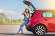 © Oleksandr Kozak - Young woman traveler sitting on hatchback car with outdoor sunny  background