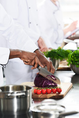 Close-up view of african american chef cutting cabbage