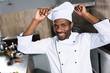 © LIGHTFIELD STUDIOS - African american chef putting white toque on his head