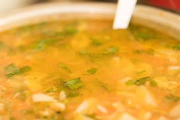 Close-up: a delicious chicken soup is in a saucepan with a ladle. Concept: tasty and healthy food.