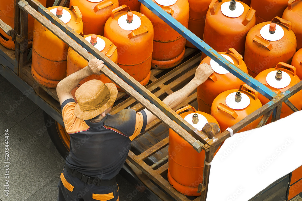delivery worker with gas butane bottles - obrazy, fototapety, plakaty 
