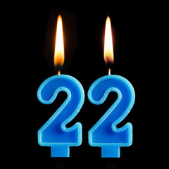 Burning birthday candles in the form of 22 twenty two for cake isolated on black background. The concept of celebrating a birthday, anniversary, important date, holiday