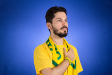 Brazilian Supporter Of National Team Of Football Is Listening To National Anthem With Hand On The Chest.