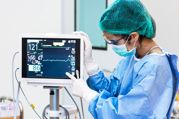 female doctor pointing to heart rate monitor in operation room.healthcare and medical concept. hospi