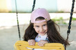 © kaganskaya115 - Happy little girl having fun with swing in the park. Children playground. Summertime.