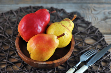 Wall Mural - fresh red and yellow pears in wooden plate