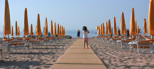 Sticker - the small child got lost among the beach umbrellas