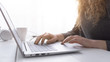 © StockPhotoPro - Woman sitting at desk and connecting with her laptop, she is working and typing on the keyboard, hands close up