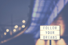 Follow Your Dreams Inspirational Life Quote Text In Lightbox, City Lights In Background, Color Toned Picture.
