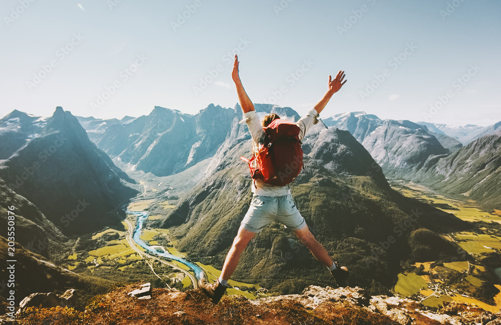 Happy Man traveler jumping with backpack Travel Lifestyle adventure concept active summer vacations outdoor in Norway mountains success and fun euphoria emotions - obrazy, fototapety, plakaty 