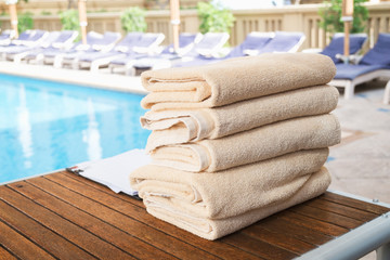 Aufkleber - Stack of clean towel on wooden table near pool for service customer
