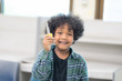 © Nattanon - Very happy African ethnicity boy with Big Key in hands laughing happily. Children Learning Class in Library. Setup studio shooting.