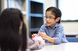 © Nattanon - Selective focus at pig jar. Kids playing collect money with a pink saving Pig Jar in the Library. Setup studio shooting.