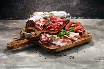 Wall Mural - Food tray with delicious salami, ham,  fresh sausages and herbs. Meat platter with selection