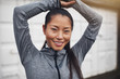 © Flamingo Images - Smiling Asian woman standing alone outdoors before a run