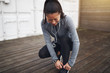 © Flamingo Images - Young Asian woman tying her running shoes before a jog