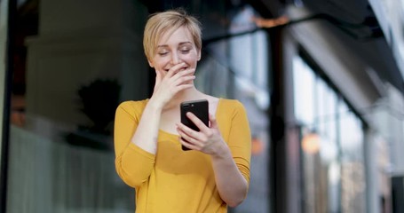 young adult female laughing at smartphone