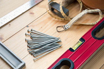 Wall Mural - Tool kit of the carpenter lie on a wooden floor.  Hammer, level, a roulette in a leather cover, nails