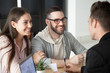 Excited smiling millennial couple discussing mortgage loan investment or real estate purchase with realtor, happy young clients customers being consulted by financial advisor, broker or architect