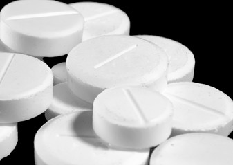 white round tablets on a black background closeup