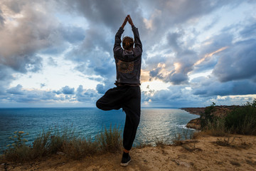 Incredible beauty of nature. A man from the back enjoys amazing views. Sunset at the sea. Partly cloudy. A storm comes.