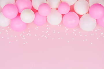 pastel balloons and white confetti on pink background top view. flat lay style.
