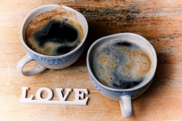 Wall Mural - Two cups of coffee and love inscription on the wooden table