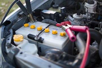 car battery clamped with jumper cable to recharge the power