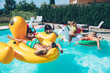 © oneinchpunch - group of friends having fun in the swimming pool