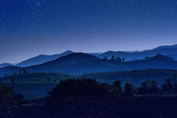 starry night with beautiful landscape view of hill layers against with blue night sky